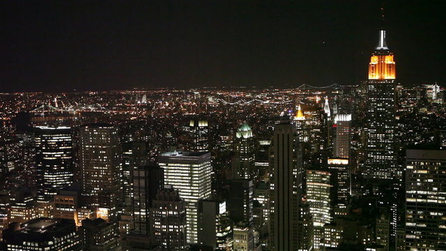 Video footage of the blinking lights of the skyscrapers of mid-town Manhattan, NYC, with the familiar Empire State building dominating the scene right of frame.