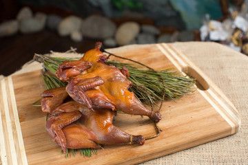 Smoked quail, partridges, chickens on a wooden