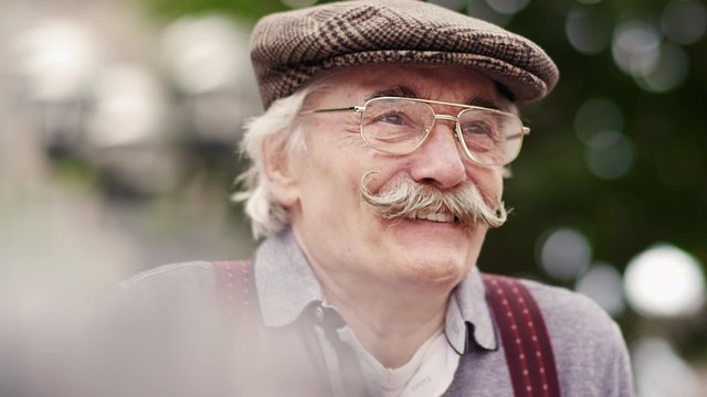 Old happy man sitting in nature 
