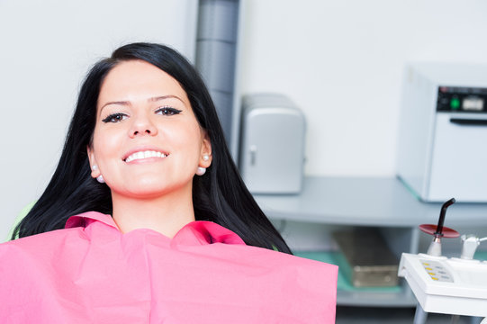 Smiling woman patient at dentist with copy space