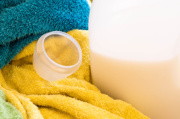 Empty measuring cup with a bottle on towels