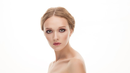 Naklejka premium Closeup beauty portrait of young adorable blonde woman with trendy makeup posing with bare shoulders on white studio background 