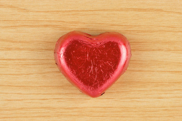 Obraz na płótnie Canvas chocolate candy red heart on wooden background.