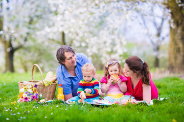 Family enjoying picnic in blooming garden