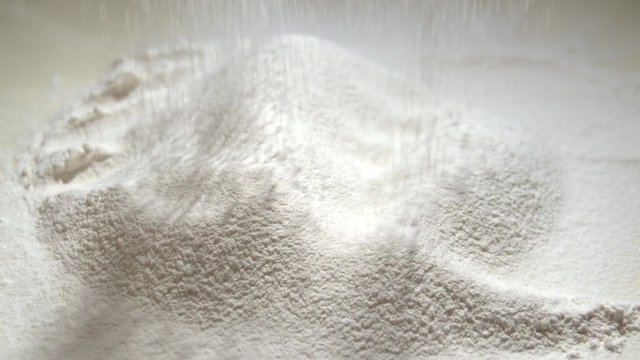 Flour through the sieve falls onto the table.  Slow motion 240 fps. 