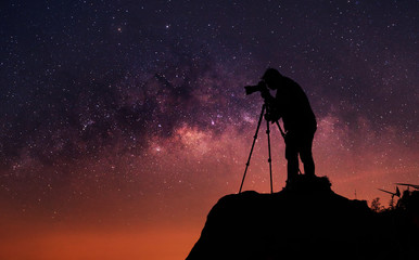 Silhouette of a photographer who shooting a milky way