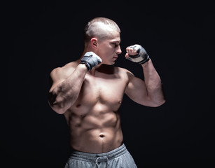 male muscular fighter isolated on black background