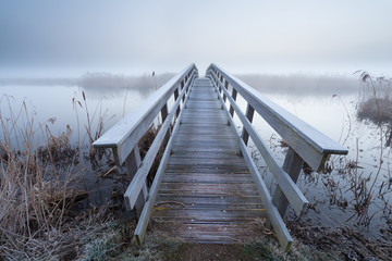 Holzbrücke über Fluss im Winter