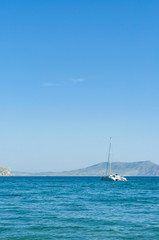 Fototapeta premium View of the Black Sea bay and moored yacht in village of Novyi Svit (New World) in summer, Crimea, Ukraine