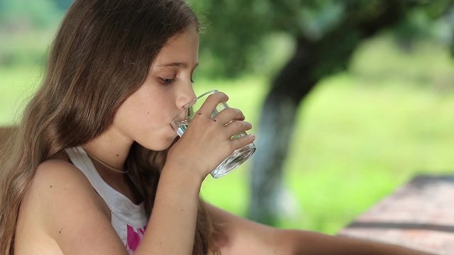 Beautiful girl drinks clean water from a glass. Girl with glass of water. Female drinks water