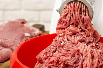 Closeup of minced meat coming out from grinder.