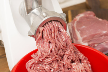 Closeup of minced meat coming out from grinder.