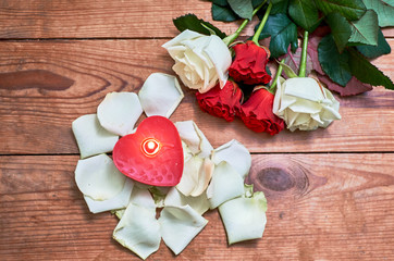 bunch of red roses with red candle on wooden background