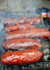Grilling sausages on barbecue grill