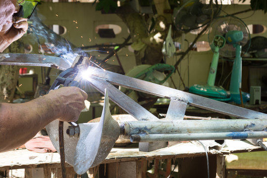 Man is repairing a long tail boat