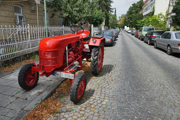 roter Traktor parkt auf Straße mitten in München
