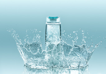 Moisturizing shampoo for dry hair. The  bottle of clear liquid stays on the turquoise water background with big  splash