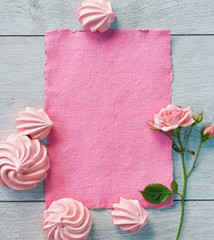 Pink paper and zephyrs for valentine's day on wooden background. View from above. Valentines Day concept