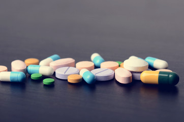 Pharmacy background on a black table. Tablets on a black background. Pills. Medicine and healthy. Close up of capsules.