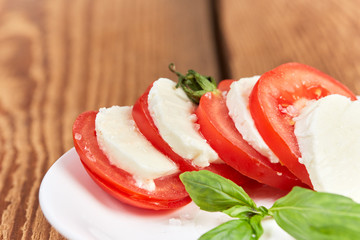 Mozzarella tomato salad on brown table