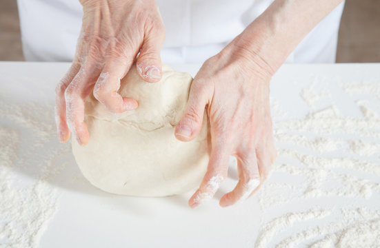 Unrecognizable female cook kneading dough