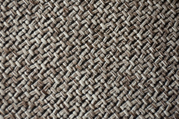 A macro image of a repetitive pattern created by the texture of woven fabric.