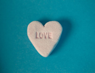 Fototapeta premium this piece of heart shaped candy with the word love printed into it makes a good valentine stock photo