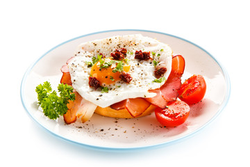Breakfast - breadroll, fried egg, bacon and vegetables 