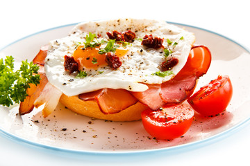 Breakfast - breadroll, fried egg, bacon and vegetables 