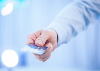 Businessman's hand giving credit card to you