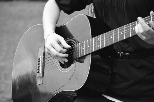 Black and white photo of guitarist playing acoustical guitar