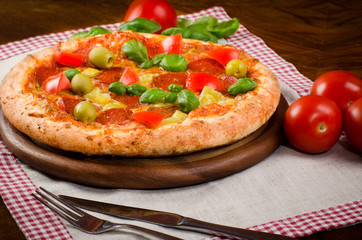 homemade pizza with salami, pepperoni, Basil and tomatoes