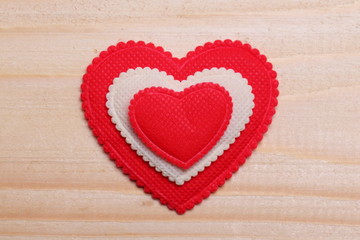 Obraz na płótnie Canvas Decorative heart. / Red and white heart on a wooden background. Decorative ribbon red-white color.