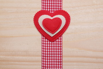 Obraz premium Decorative heart. / Red and white heart on a wooden background. Decorative ribbon red-white color.