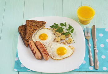 Breakfast with fried eggs, sausage, marinade mushrooms and bread
