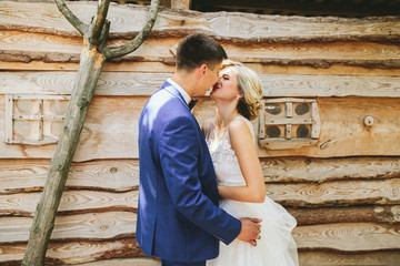 beautiful young wedding couple stands near house