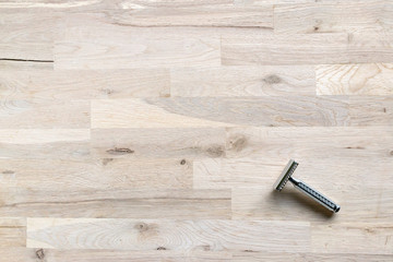 vintage chrome plated razor on a grain oak tree background seen from above