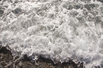 Wave on the pebble coast of sea