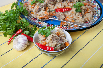 Hot delicious pilaf on a turkish plate on yellow striped tablecl