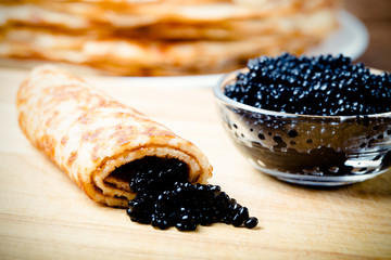 Russian pancakes - blini with black caviar. Shallow depth of fie