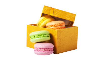 Macaroons in gold box isolated on white background