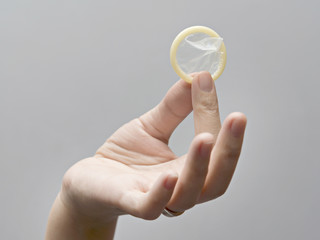 Female hand holding condom