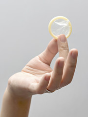 Female hand holding condom