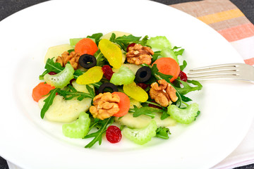 Dietary delicious salad on white plate of arugula, pear, walnut 