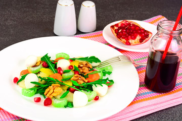 Dietary delicious salad on white plate of arugula, pear, walnut,