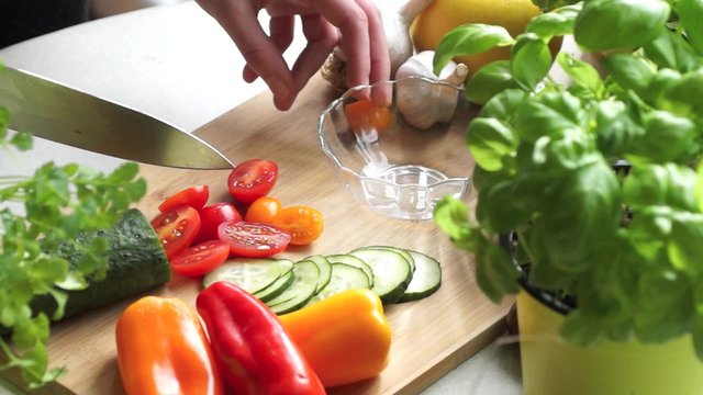 Young woman cutting vegetables for salad