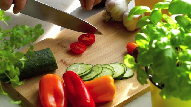 Young woman cutting vegetables for salad
