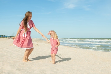 Naklejka premium Mother and her daughter having fun on the beach