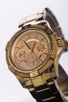 Gold watch on a plastic background