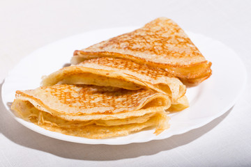 Three pancakes on a white plate
